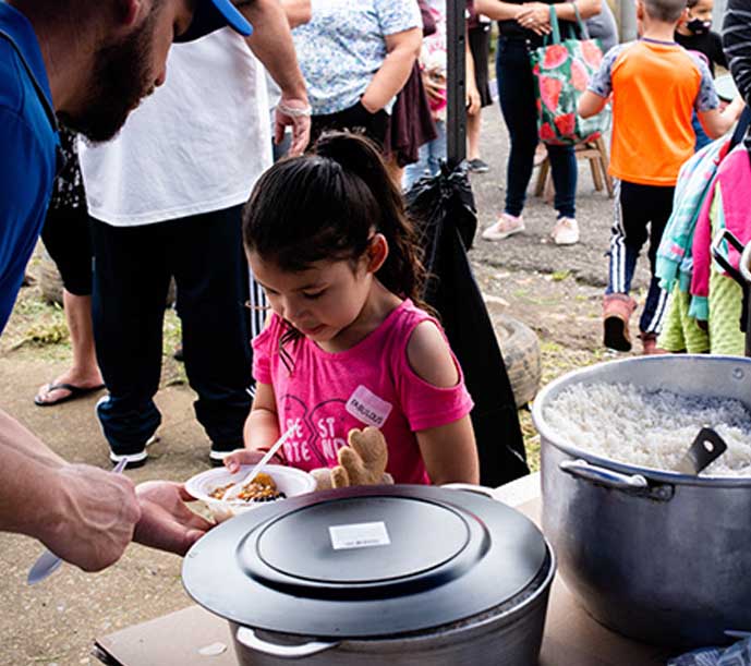 Image of a little girl being served warm, nutritious Breedlove food.