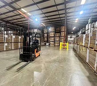 Image of Breedlove warehouse with boxes of stored food with forklift in the scene.