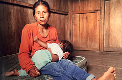 Woman Holding Baby on Mattress